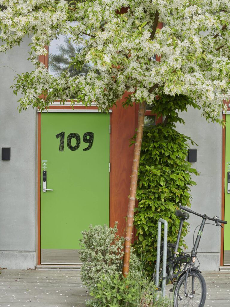 Närbild på cykelverandan på Ohboy Hotell med cykeln och gröna fasaderna.